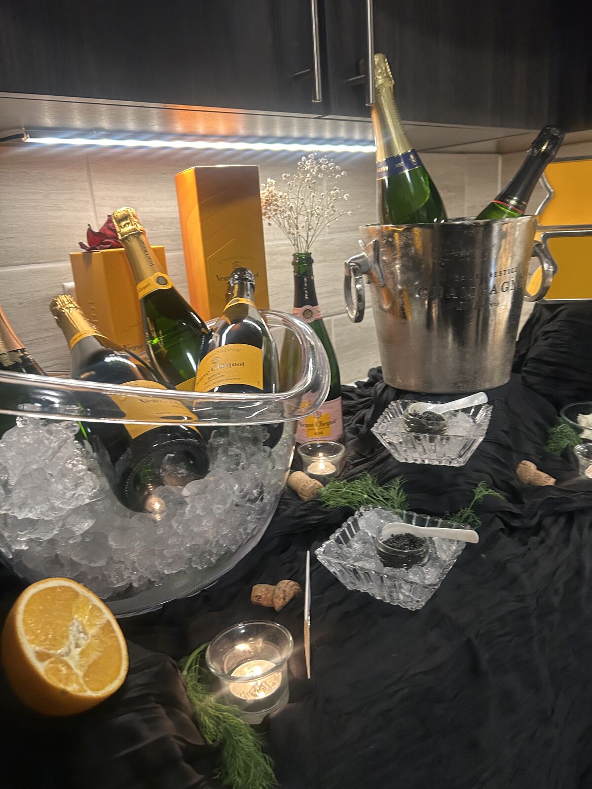Beverage bar with champagne on ice, glassware and citrus garnish