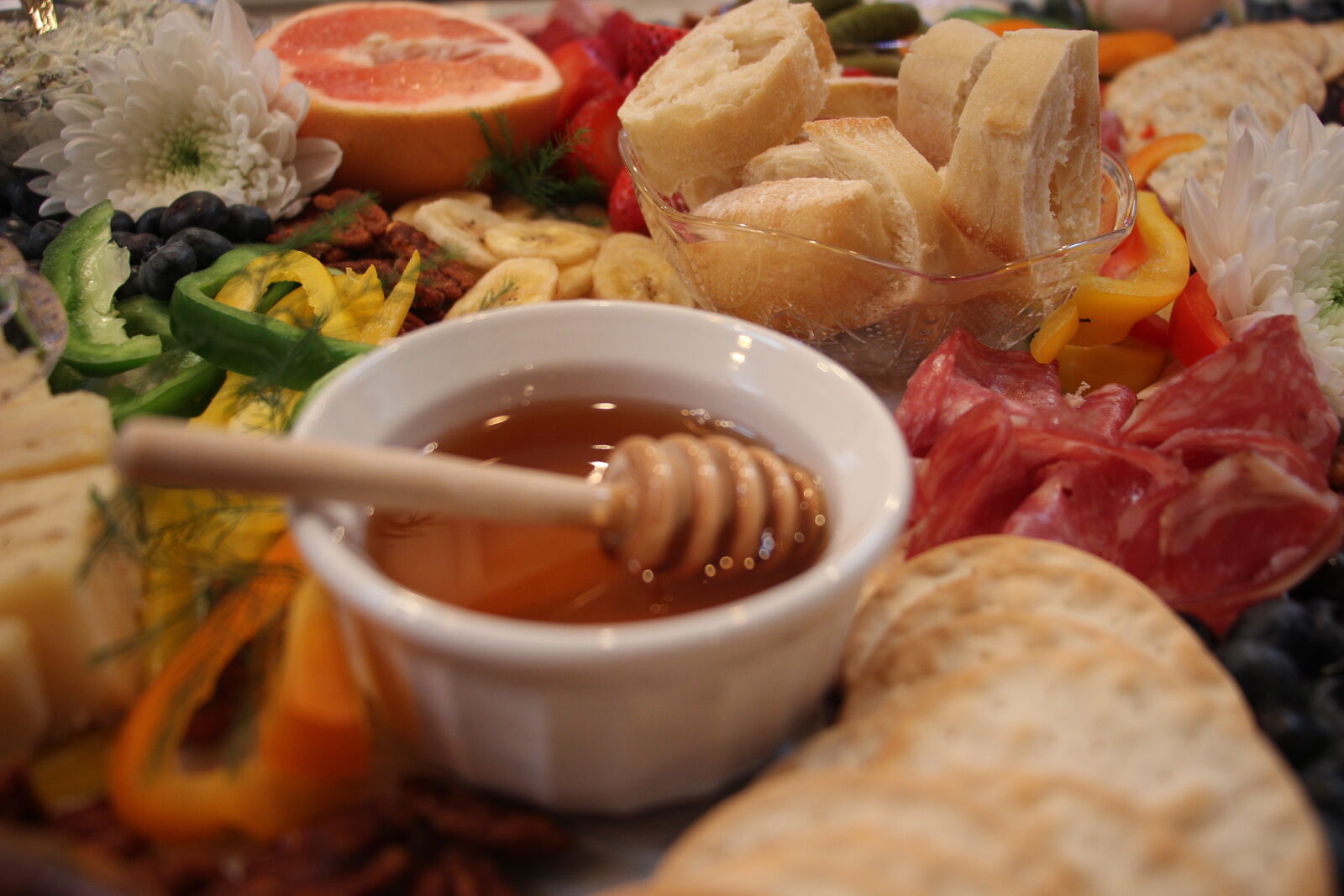 Close-up of a honey pot and charcuterie on a styled grazing board