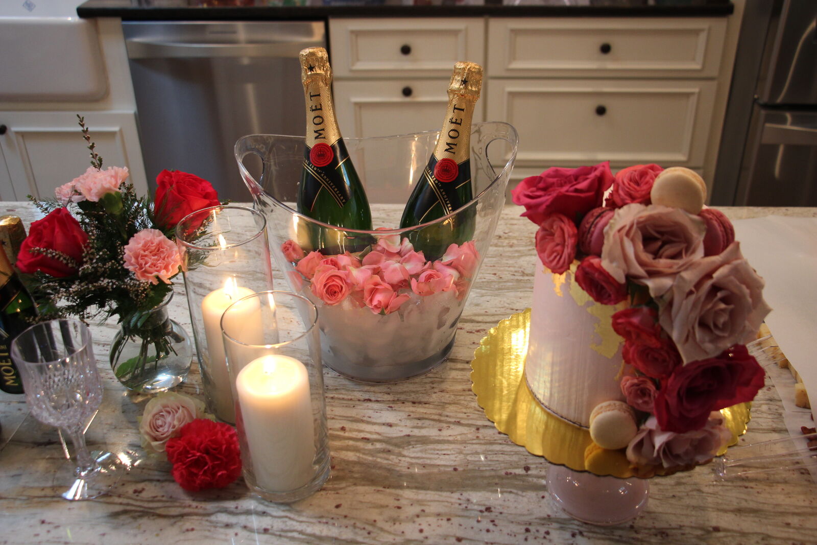 Champagne tower and floral celebration cake on a candlelit kitchen island