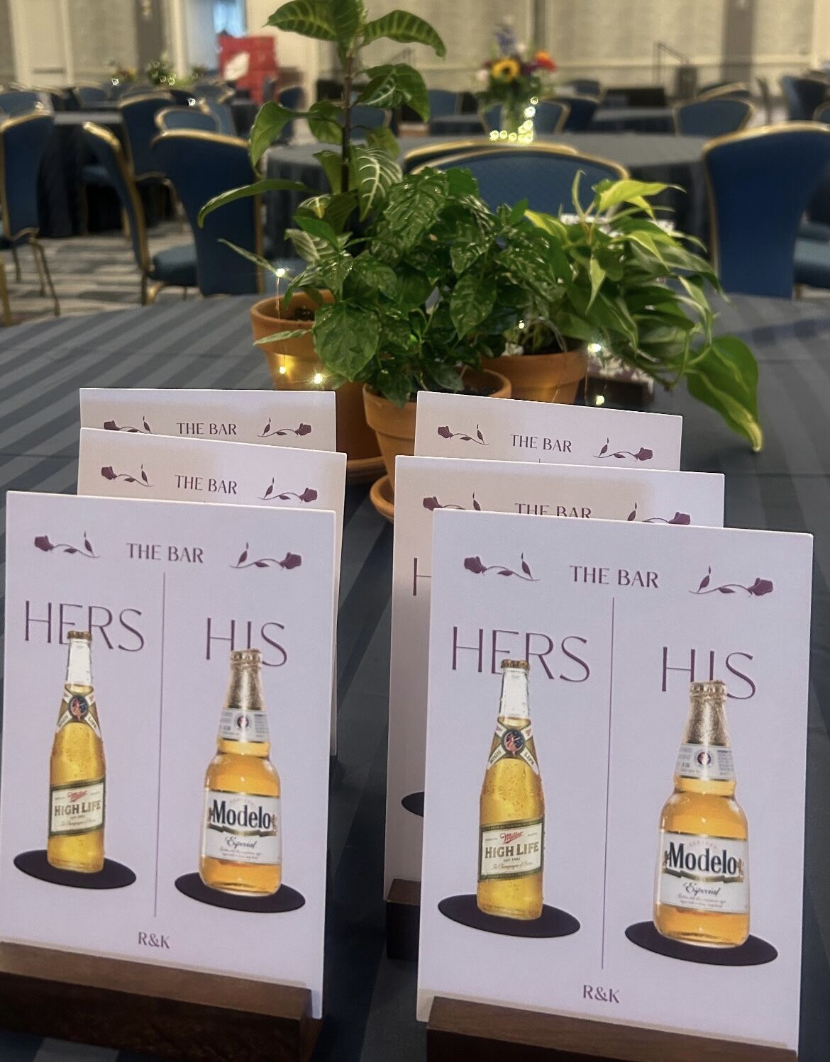 Custom His and Hers bar signage with potted-plant centerpieces